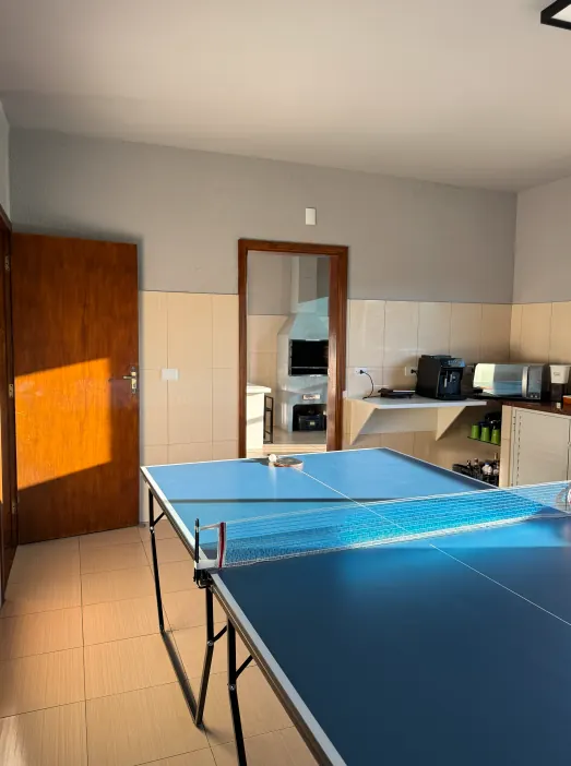 Espaço de descompressão com mesa de pingue-pongue e copa